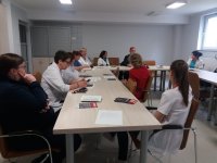 zdjęcie przedstawia dzielnicowego gminy Mońki oraz grupę pielęgniarek SP ZOZ Mońki. na stołach widoczne są ulotki promujące program profilaktyczny &quot;poMOC, a nie przeMOC&quot;