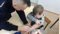 policjant bandażuje rękę dziecka