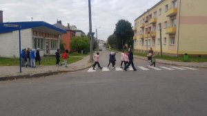 policjanta z dziećmi przechodzą przez przejście dla pieszych