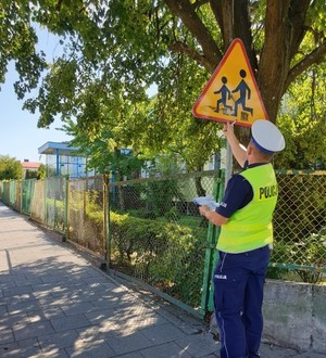 policjant ruchu drogowego sprawdza oznakowanie w rejonie przedszkola
