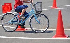 dziecko na rowerze na boisku, pacholki