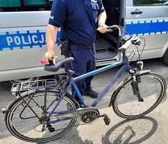 policjant trzymający rower