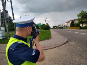 policjant mierzący prędkość na terenie powiatu monieckiego