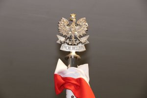 metalowe godło Polski oraz napis Policja