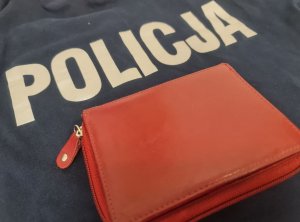 na granatowym tle z białym napisem policja leży portfel koloru czerwonego