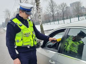 policjant ruchu drogowego sprawdza stan trzeźwości kierowcy