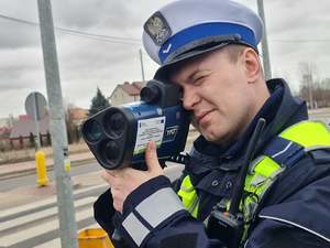 policjant w trakcie sprawdzania prędkości poruszających się pojazdów
