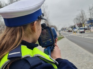policjantka mierzy prędkość w rejonie przejścia dla pieszych