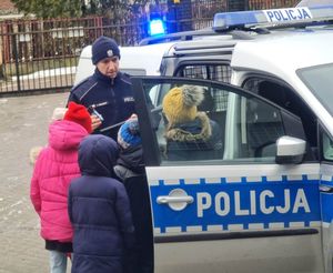 dzieci oglądają wyposażenie policjanta pełniącego służbę patrolową