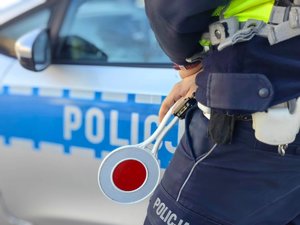 policjant trzyma tarczę do zatrzymywania pojazdów