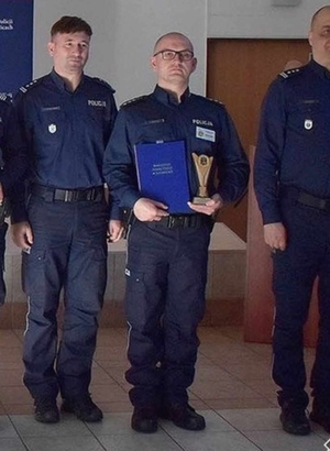 na zdjęciach policjanci uczestniczący w konkursie na najlepszego dzielnicowego na tle ścianki w Szkole Policji w Katowicach