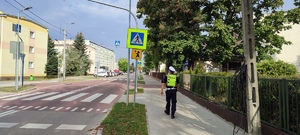 policjant idący w okolicach budynku szkoły