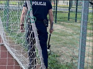 policjant z urządzeniem pirotechnicznym, boisko sportowe