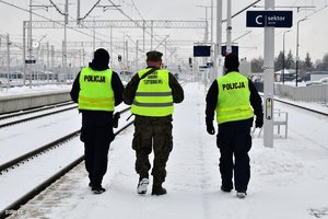 na zdjęciu policjanci idący na peronie wzdłuż torów